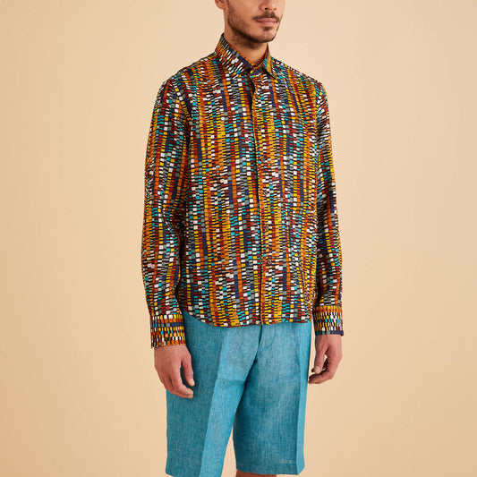 Person wearing an Inserch LS Geo Print Linen Shirt in cacao and blue shorts, standing against a plain beige background.