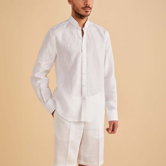 A man wearing the Inserch LS Linen Banded Collar Shirt LS716-00002 in white by Inserch, paired with matching white shorts, stands against a beige background.