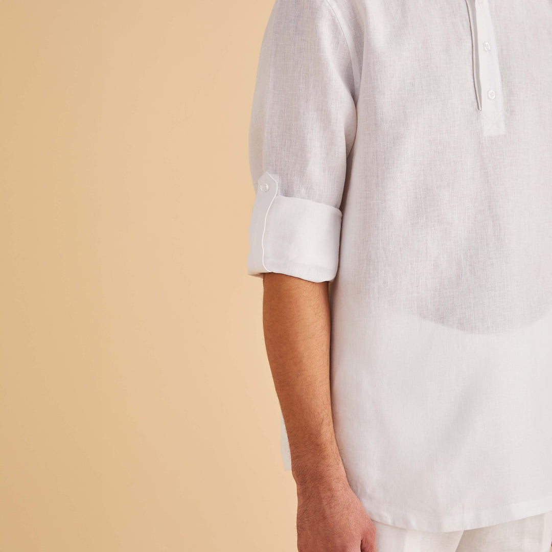 A man in an Inserch LS Linen Pull Over Shirt (White) stands against a plain beige background, exuding effortless elegance.