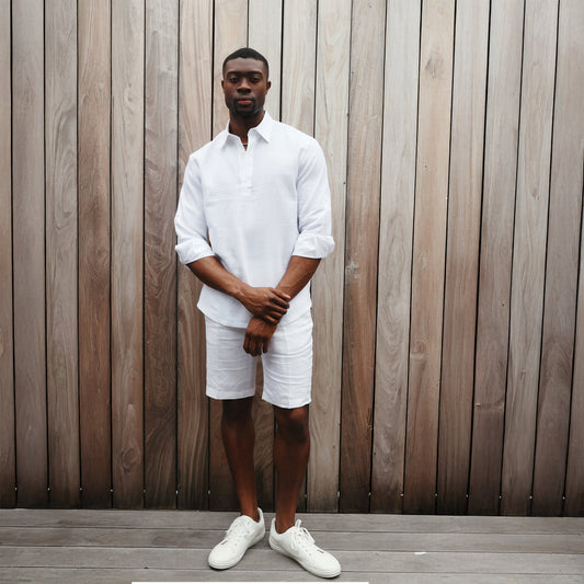 A man in an Inserch LS Linen Pull Over Shirt (White) stands against a plain beige background, exuding effortless elegance.
