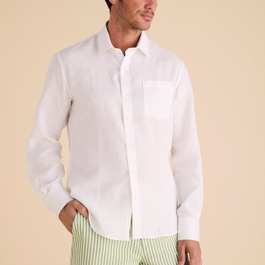 A man wears the Inserch Long Sleeve Modern Fit Linen Shirt LS881-00002 in white, featuring a chest pocket, paired with green-and-white striped pants against a beige background.