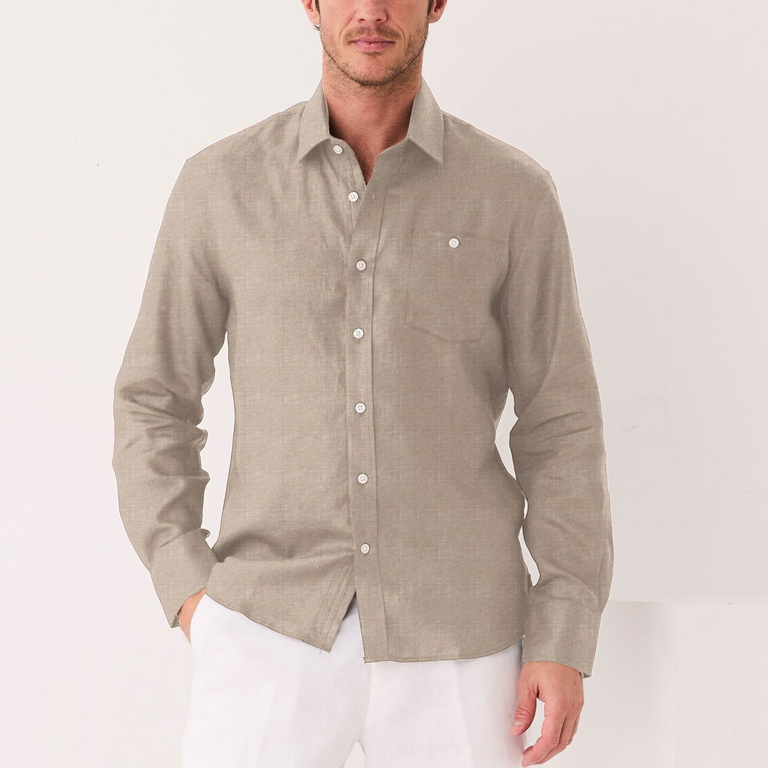 A man wears the Inserch Long Sleeve Modern Fit Linen Shirt LS881-00048 Natural by Inserch—light brown with a chest pocket—paired with white pants, standing against a plain white background.