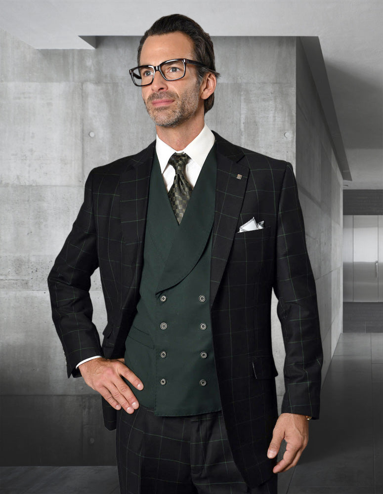 Wearing the STATEMENT CLOTHING | LUCCA-BLACK-HUNTER suit by Statement Clothing, a man with glasses and modern fit pants stands in a minimalist interior with sleek concrete walls.
