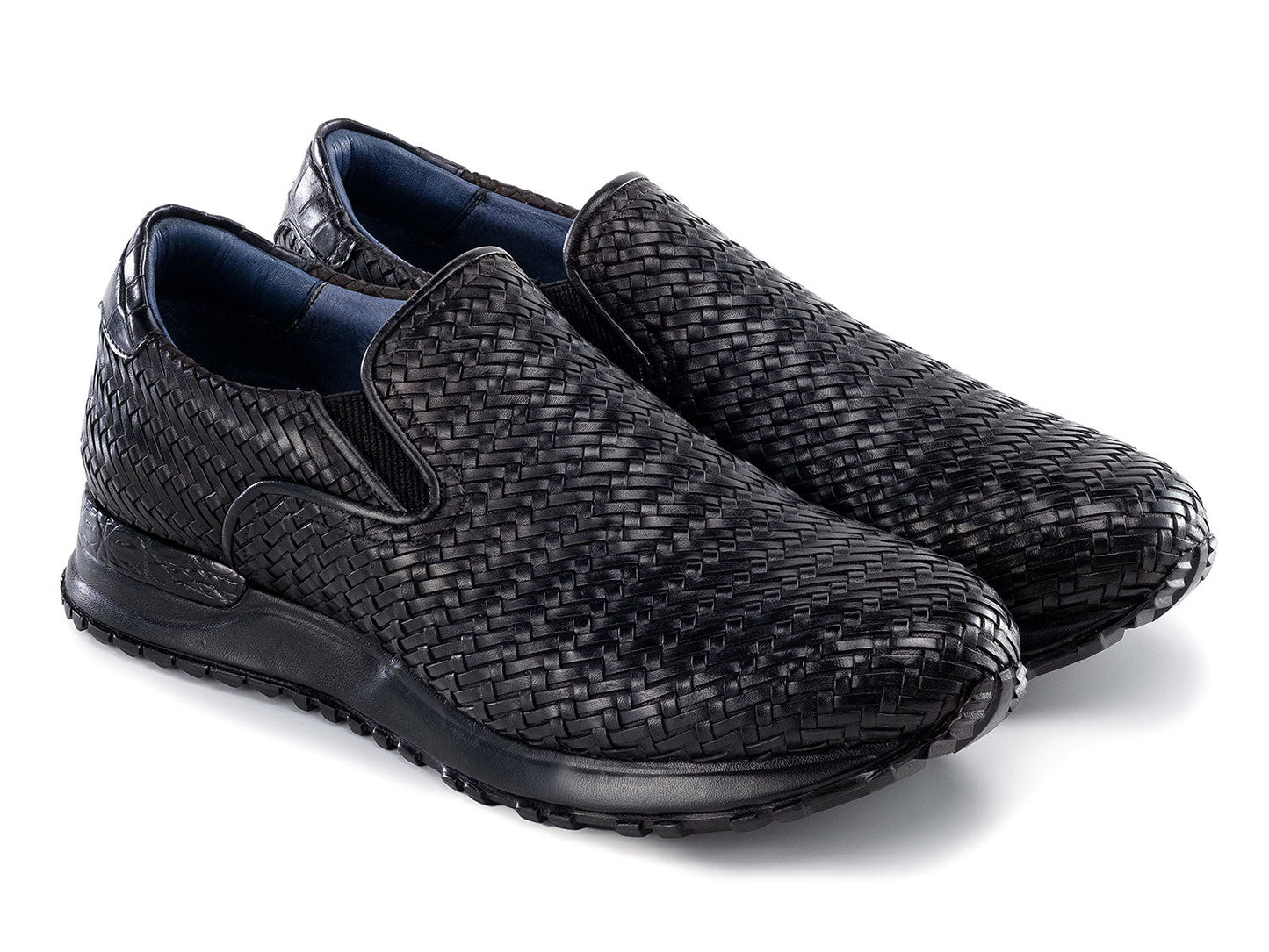 Paul Parkman Men's Black Woven Leather Slip-On Sneakers (LW204BLK) are shown against a white background, featuring stylish textured soles with one shoe resting atop the other.