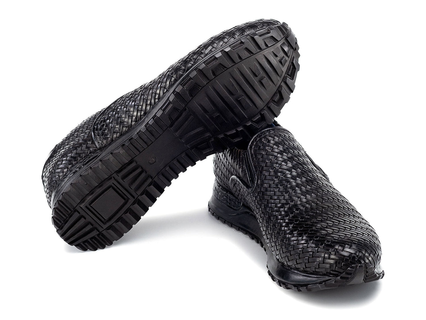 Paul Parkman Men's Black Woven Leather Slip-On Sneakers (LW204BLK) are shown against a white background, featuring stylish textured soles with one shoe resting atop the other.