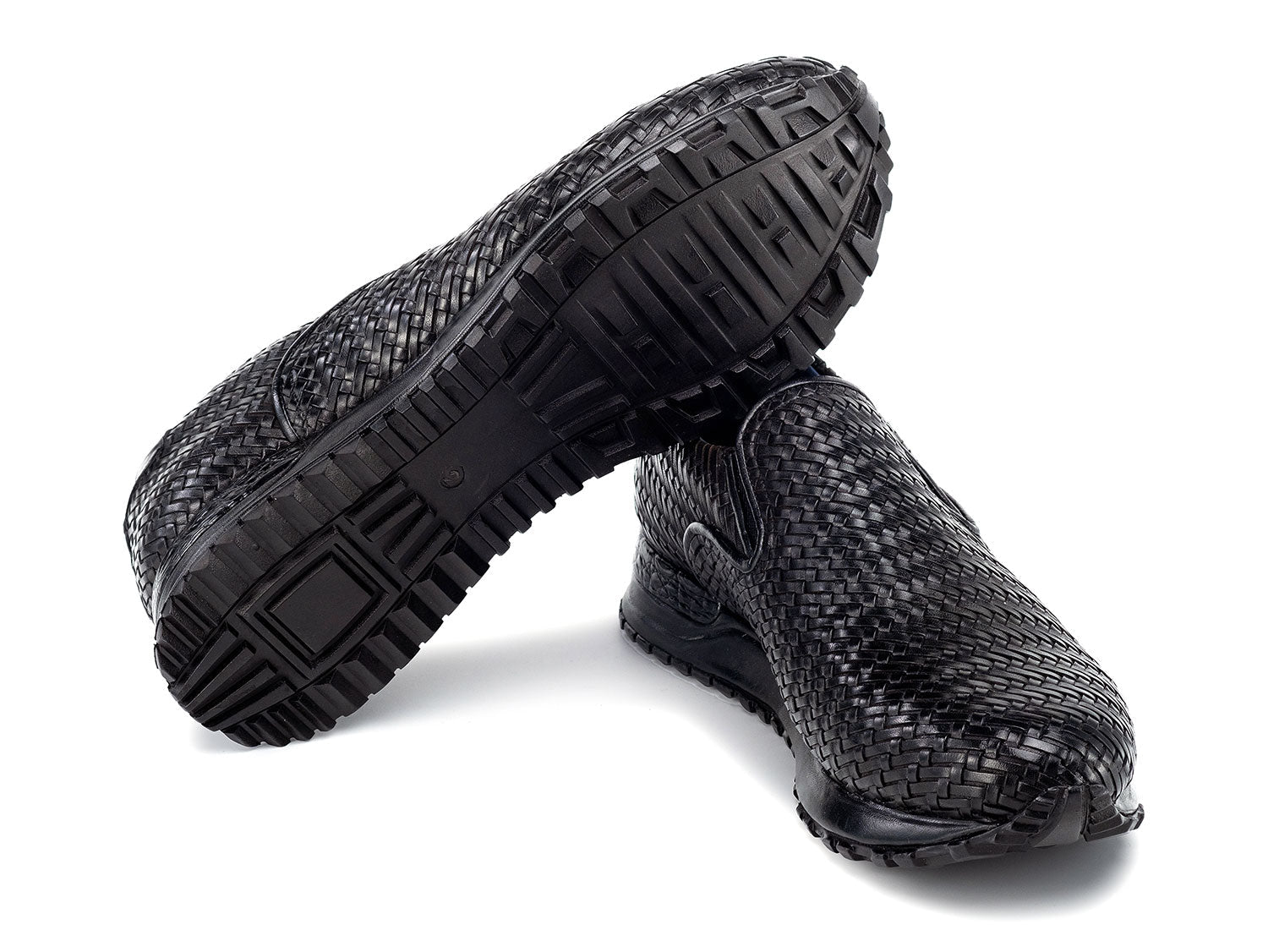 Paul Parkman Men's Black Woven Leather Slip-On Sneakers (LW204BLK) are shown against a white background, featuring stylish textured soles with one shoe resting atop the other.