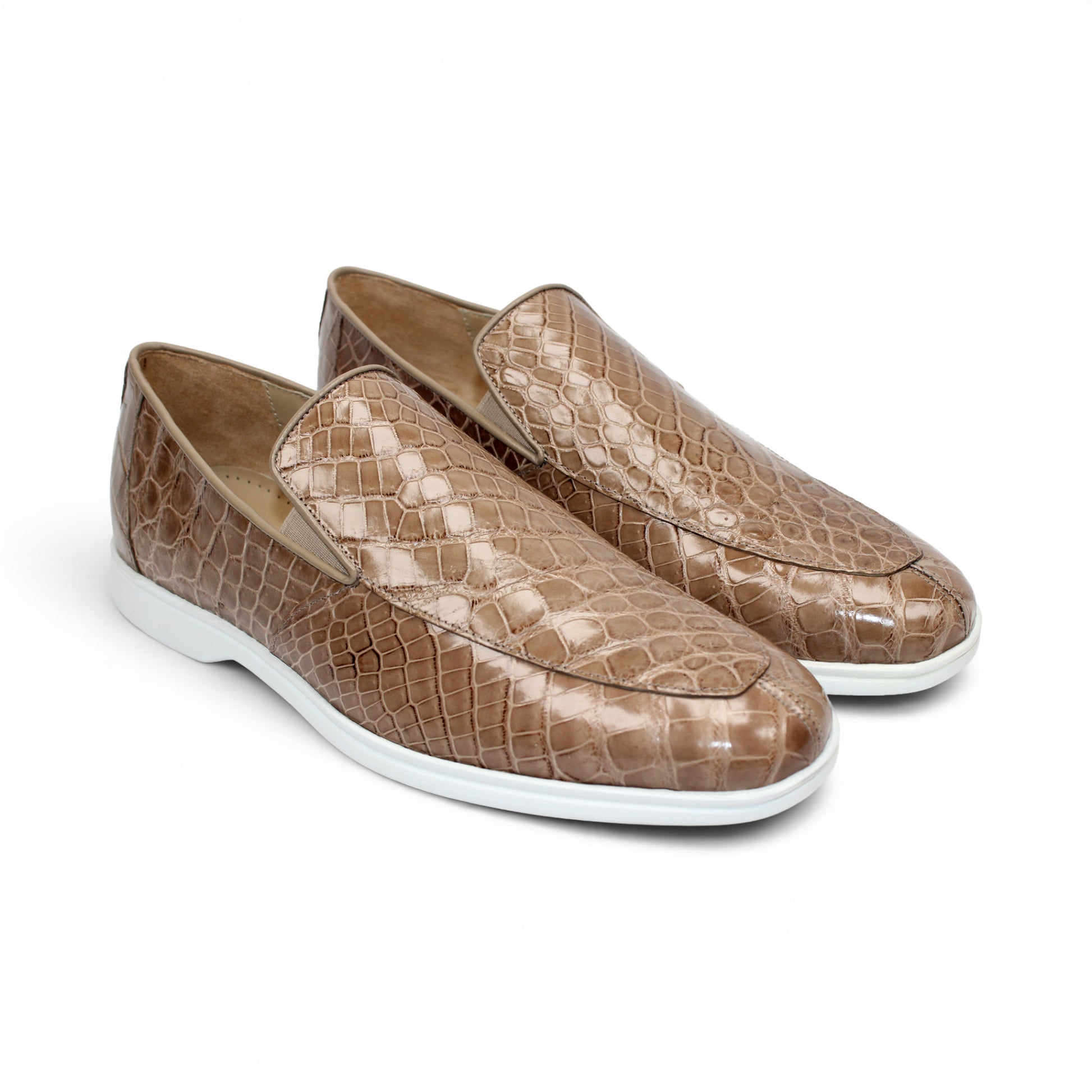 The Fennix Lance Taupe by Fennix of Italy, a taupe crocodile-patterned loafer with a crisp white sole, is displayed in profile against a white background—an exquisite example of luxury men's footwear.