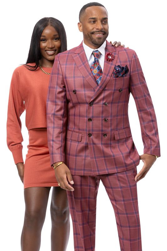 A woman in a rust-colored sweater and skirt stands behind a man dressed in the EJ SAMUEL Wine Suit M2813—a stylish double-breasted ensemble.