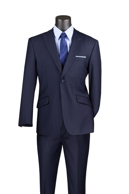 Displayed on a mannequin is Vinci Suits' Modern Fit Suit with Peak Lapel Navy M2TR, made from a wrinkle-resistant poly rayon blend. Teamed with a crisp white dress shirt and a blue tie, this ensemble embodies sophistication and style.