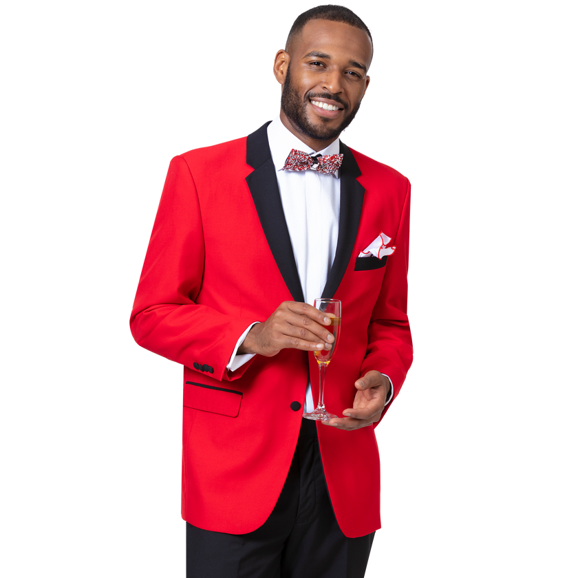 A man in the EJ Samuel Red Tuxedo M3211 by EJ SAMUEL, featuring black trim, a white shirt, patterned bow tie, and pleated pants, holds a glass of champagne and smiles at the camera.