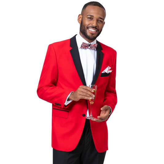 A man in the EJ Samuel Red Tuxedo M3211 by EJ SAMUEL, featuring black trim, a white shirt, patterned bow tie, and pleated pants, holds a glass of champagne and smiles at the camera.