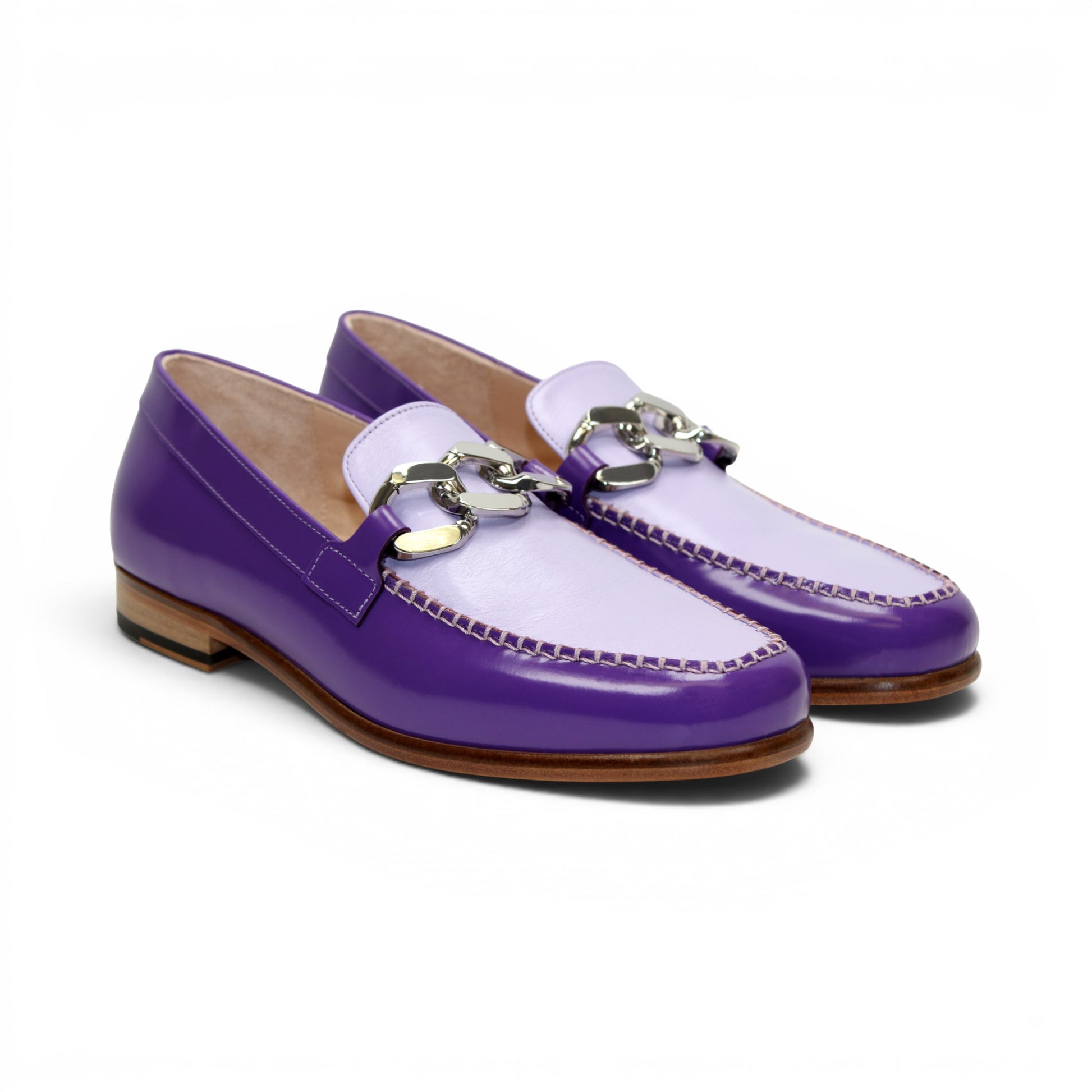 The Emilio Franco M2 Purple/Lavender loafer is an Italian-crafted shoe featuring white stitching, a metal chain detail on the upper, and a brown wooden sole.