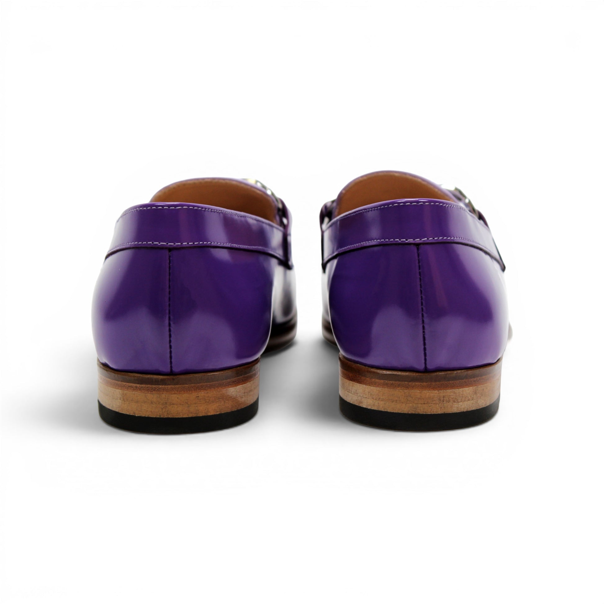 The Emilio Franco M2 Purple/Lavender loafer is an Italian-crafted shoe featuring white stitching, a metal chain detail on the upper, and a brown wooden sole.