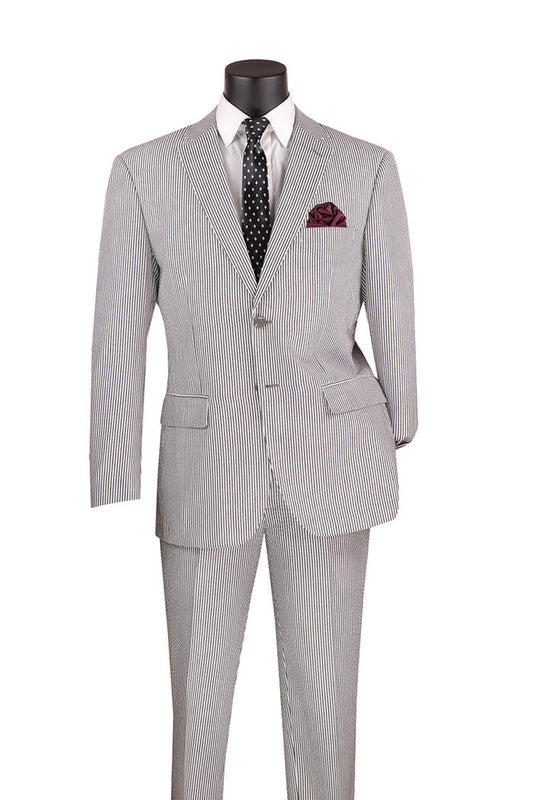 The Vinci Suits Modern Fit Summer 2-Piece Black Striped Seersucker Suit, complemented by a white shirt, black polka dot tie, and maroon pocket square for added elegance, is displayed on a sleek black mannequin torso.