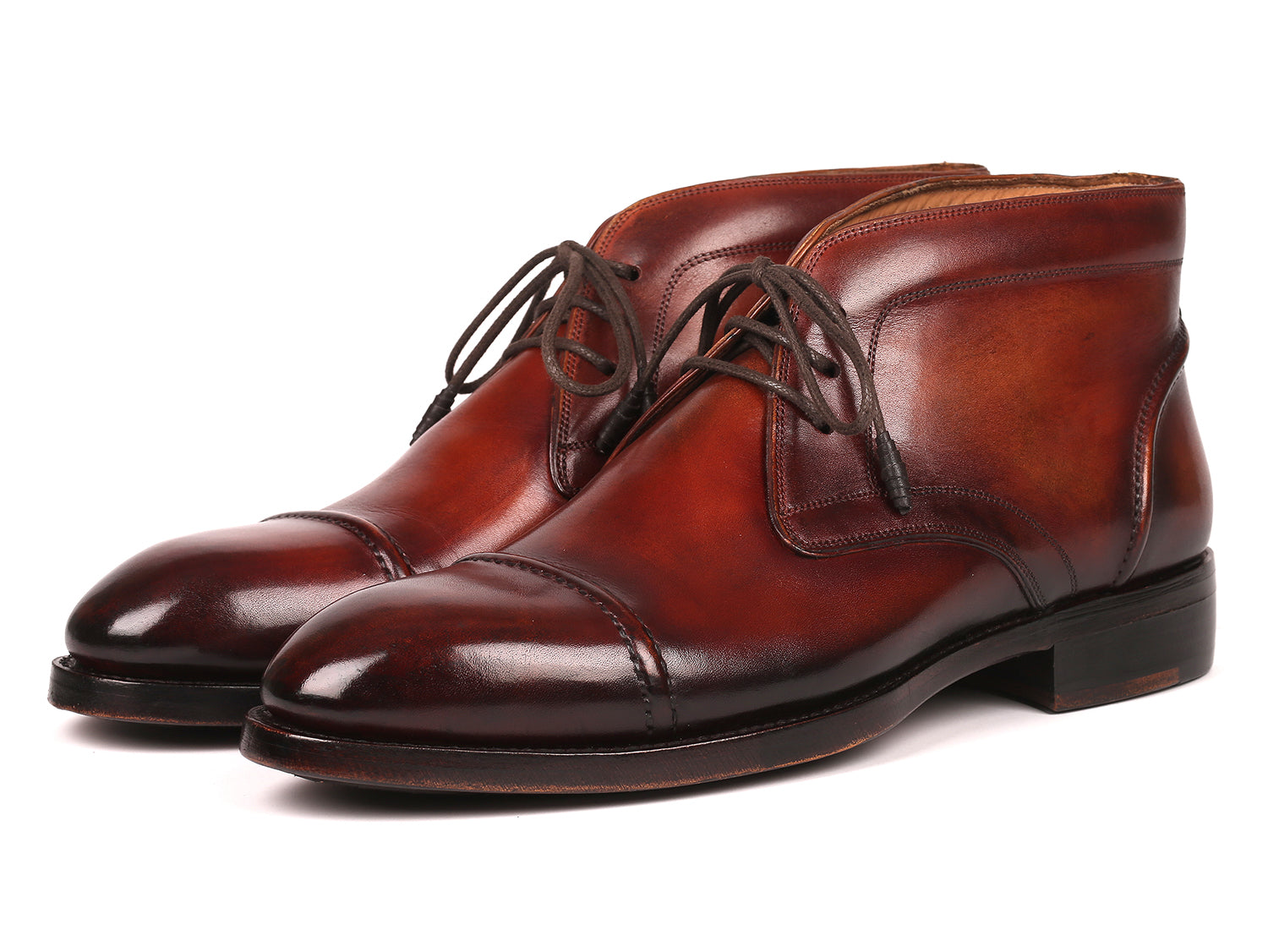 The Paul Parkman Cap Toe Chukka Boots Brown - 144BRW68, polished brown leather dress boots with laces, feature Goodyear welt construction and are displayed on a white background—one upright, the other leaning against it.