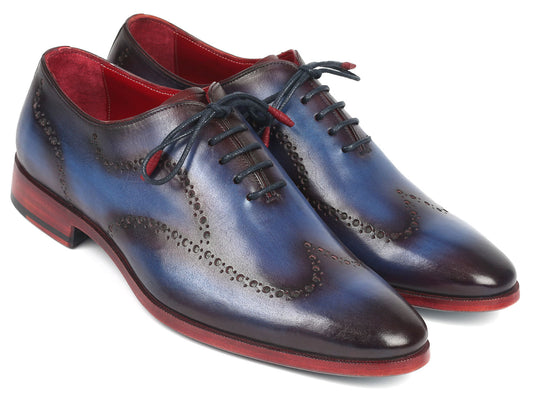 The Paul Parkman Wingtip Oxfords in Blue & Purple - 741-PRP are beautifully hand-painted calfskin dress shoes with red soles, showcasing intricate wingtip perforated designs.