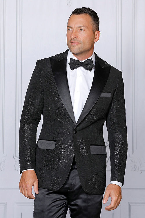 A man wearing an Insomnia MANZINI MZS-528 Reptile Texture Black Tuxedo Jacket, tailored fit, paired with a white shirt and black bow tie stands against a light gray background.