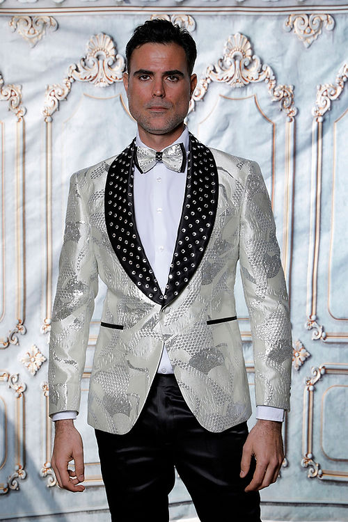 Man in a Manzini MZS-601 suit, featuring a metallic pattern and rhinestone satin lapel, paired with a bow tie.