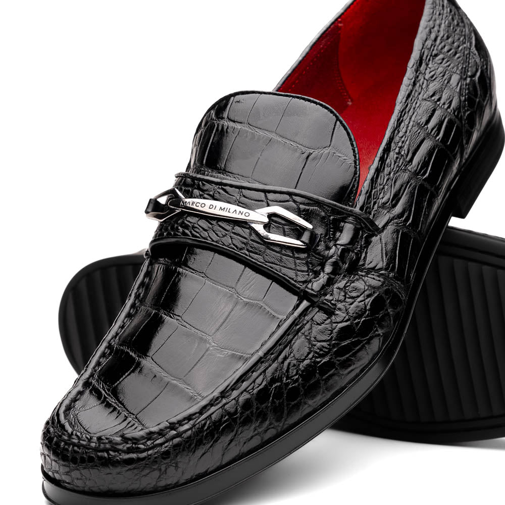 The Milan Black by Marco Di Milano is a black crocodile-pattern leather loafer with a metallic logo detail on the strap and red interior lining, epitomizing luxury men’s footwear.