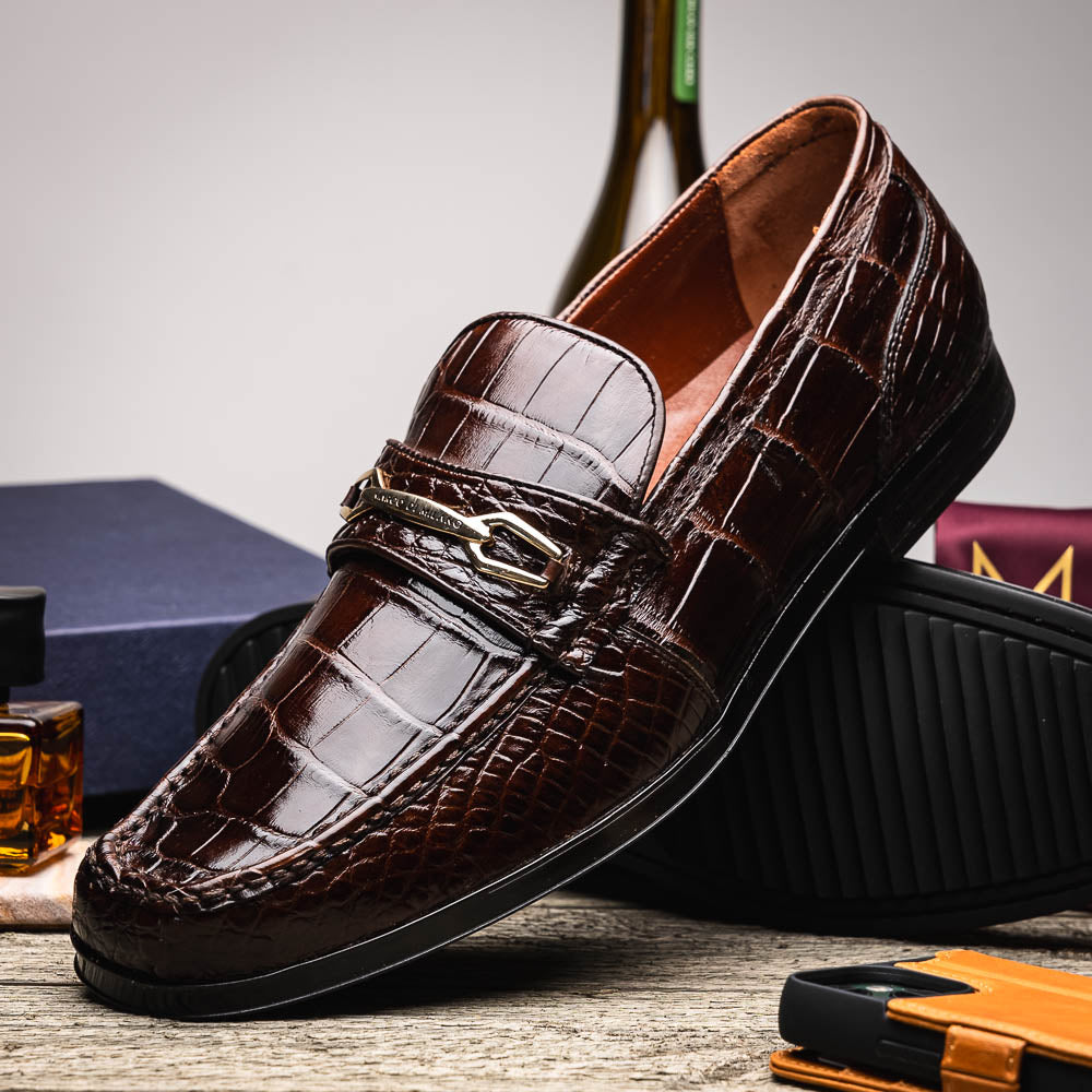 A pair of Marco Di Milano "Milan Brown" luxury loafers featuring brown crocodile-pattern leather and a metal buckle; one shoe is upright while the other is on its side, displaying the sole.