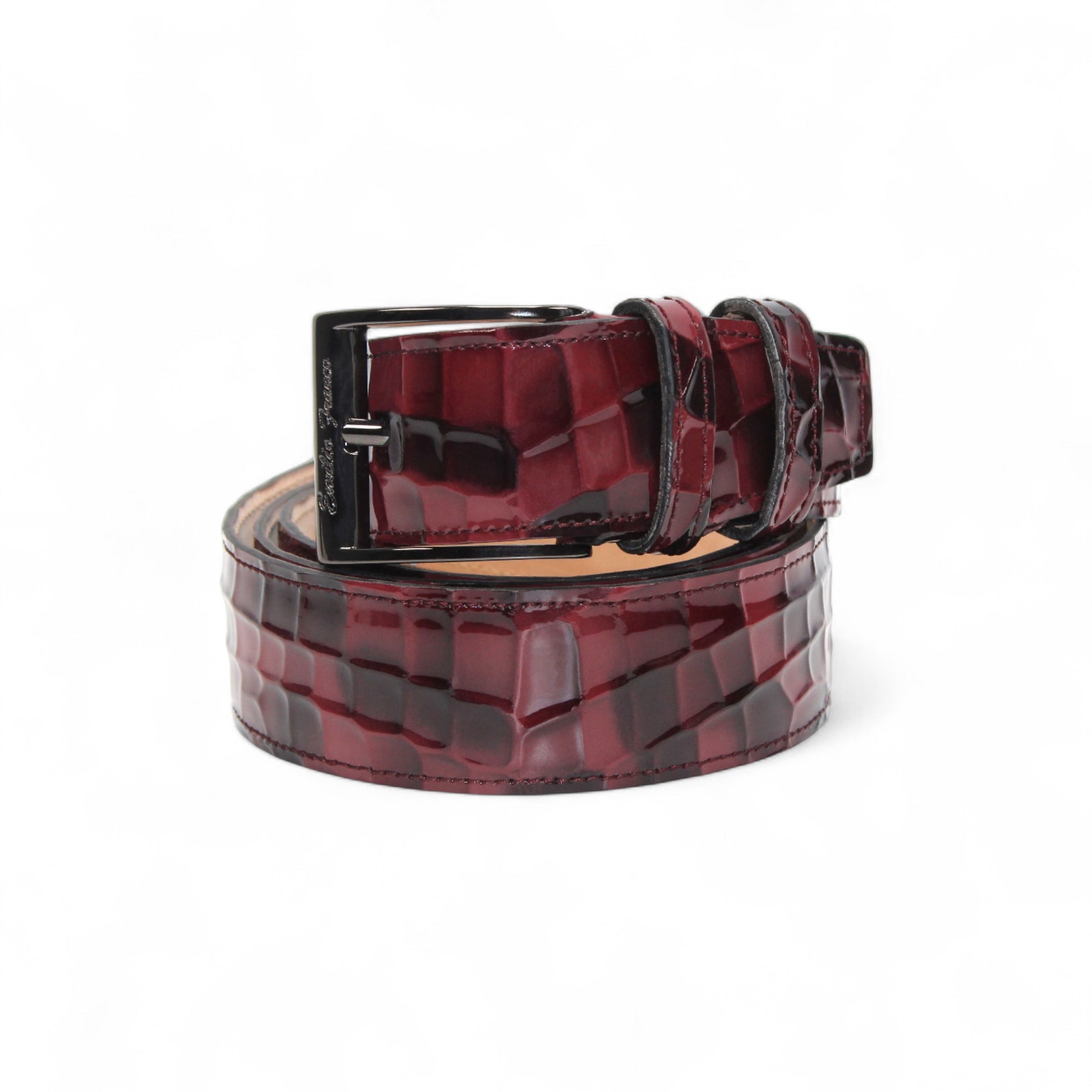 The Matiste Burgundy Leather Belt NS1 by Matiste features a maroon crocodile-patterned Italian leather and a bold metallic buckle with a raised lion head, bringing luxurious style to any outfit.