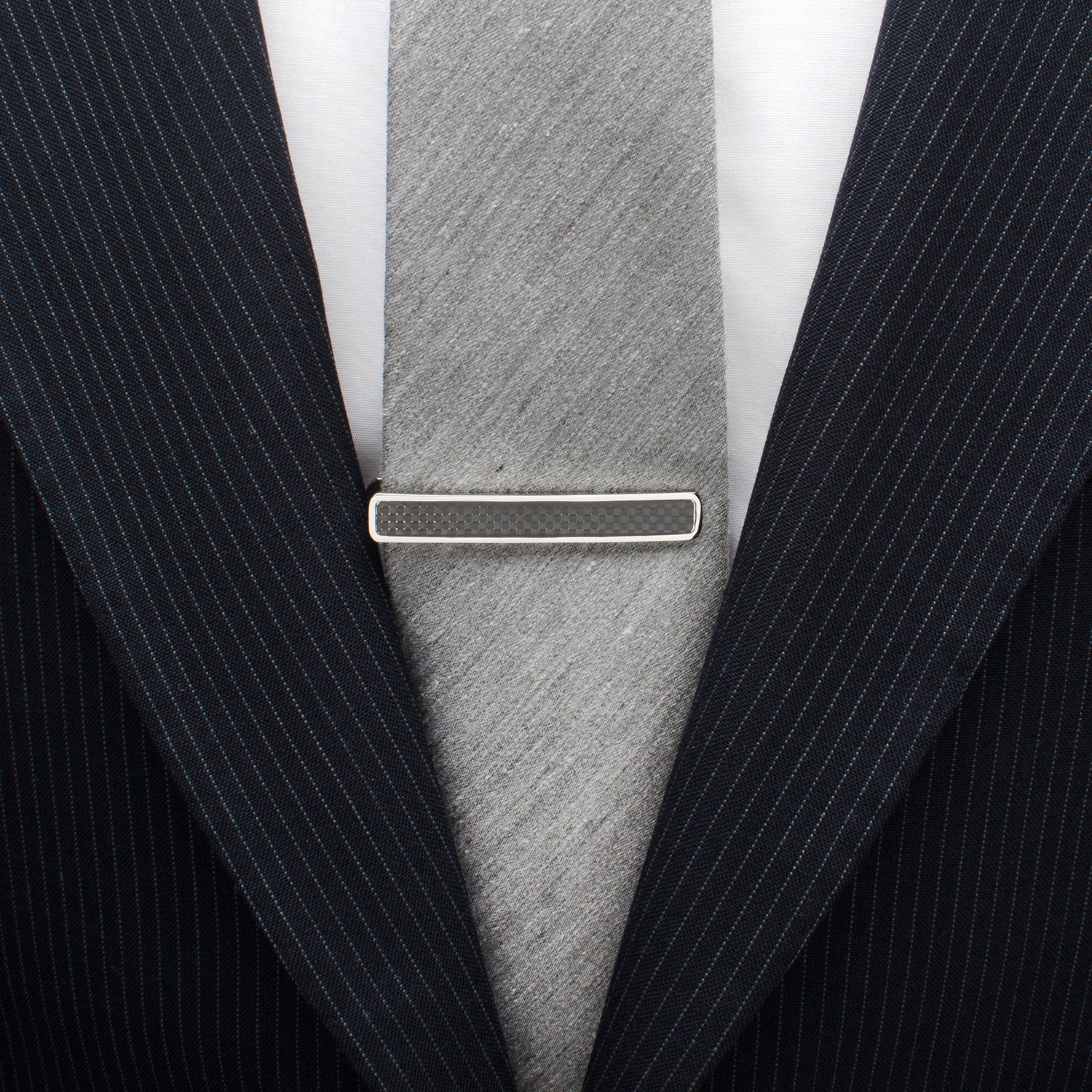 The Cufflinks.com Black Carbon Fiber Stainless Steel Tie Clip features a sleek design with a bold black carbon fiber inlay, displayed on a white background.