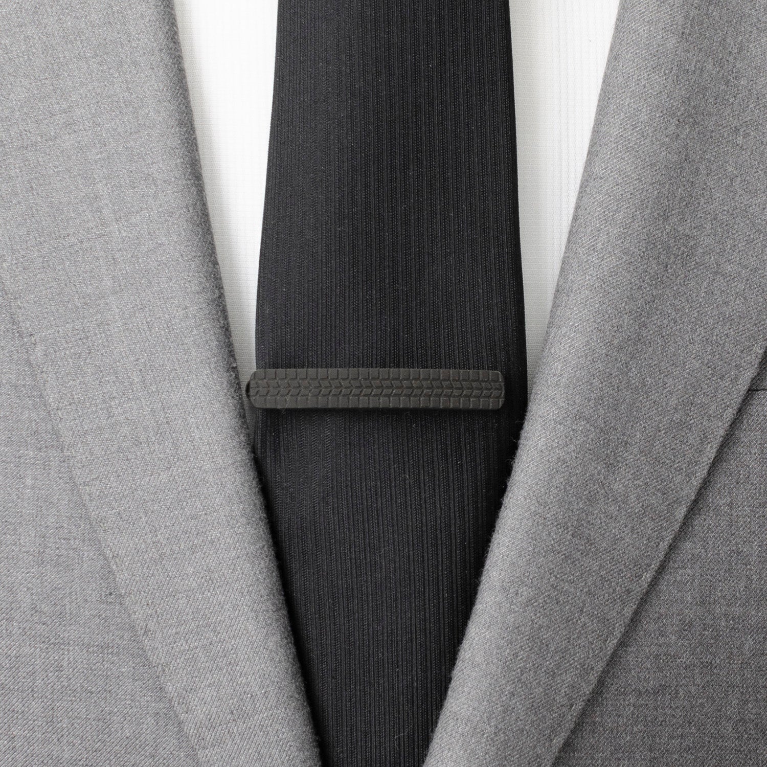 The Cufflinks.com Stainless Steel Carbon Fiber Tire Tread Tie Clip features a black, tire tread-inspired carbon fiber grip on top, displayed against a white background.