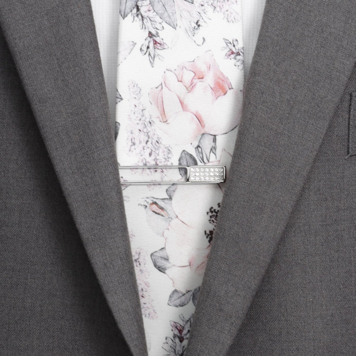 The Die Cut Crystal Stainless Steel Tie Clip by Cufflinks.com features a rectangular cutout design with a row of clear gemstones on one end, crafted from stainless steel and shown on a white background.