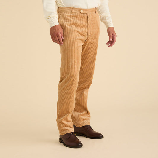 A person wearing Inserch Cotton Corduroy Pants P267-09 Khaki, a cream sweater, and brown dress shoes stands against a beige background.