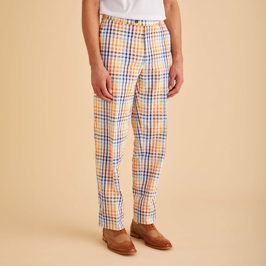 A person stands against a beige background wearing Inserch Seersucker Check Pants P271-00056 White Multi in modern fit, paired with a white shirt and brown brogue shoes. These premium cotton pants from Inserch add a touch of sophistication to the ensemble.