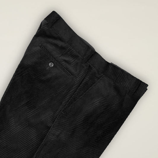 The Inserch Velvet Diagonal Pants P275-01 Black, neatly folded to reveal the buttoned back pocket, showcase a modern-fit chino style against a plain light background.