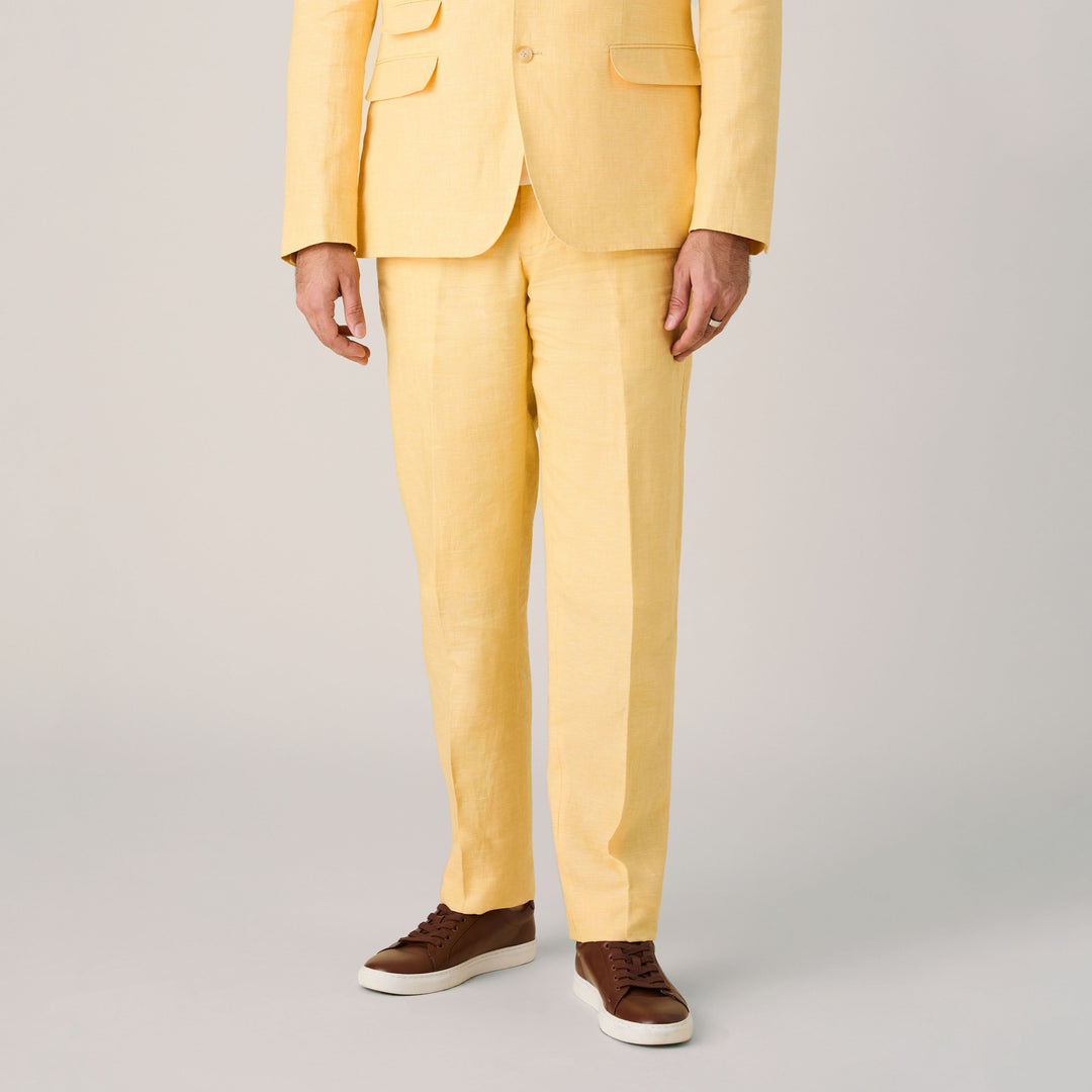 A person stands against a neutral background wearing Inserch Linen Pants P31-00055 Yuzu, tailored from premium European flax for refined comfort. Paired with brown sneakers, the image shows only the body—no head is visible.