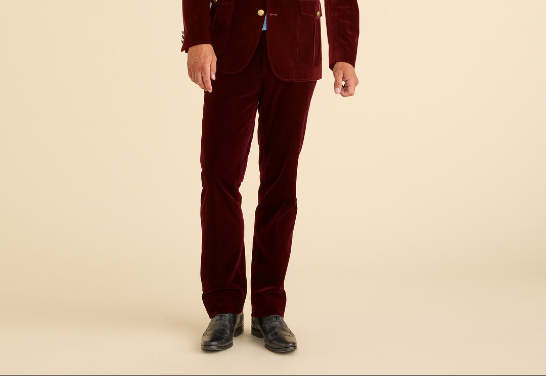 Man wearing a burgundy velvet suit on a beige background