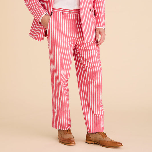 A man stands confidently against a plain beige background, wearing Inserch Seersucker Wide Stripe Pants P507-00030 Red and a matching top, both crafted for a modern fit from premium cotton, paired with stylish brown leather shoes.