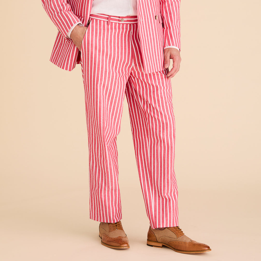 A man wears the Inserch Seersucker Wide Stripe Suit BL507-00030 Red by Inserch, paired with a white shirt and brown dress shoes, standing against a beige background.