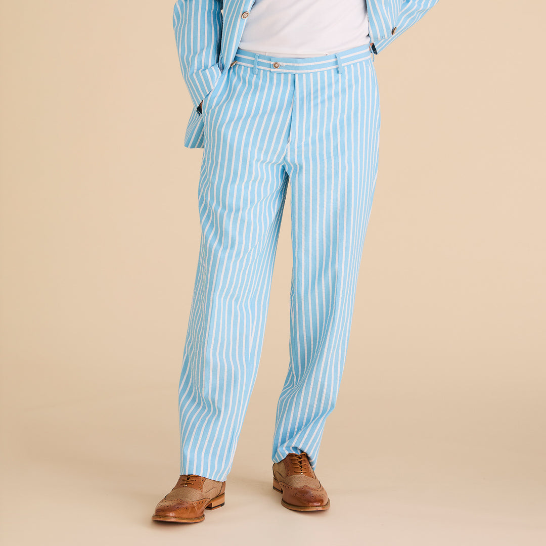 A person wears the Inserch Seersucker Wide Stripe Pants P507-00183 in Blue Mist, paired with tan dress shoes, standing against a beige background.