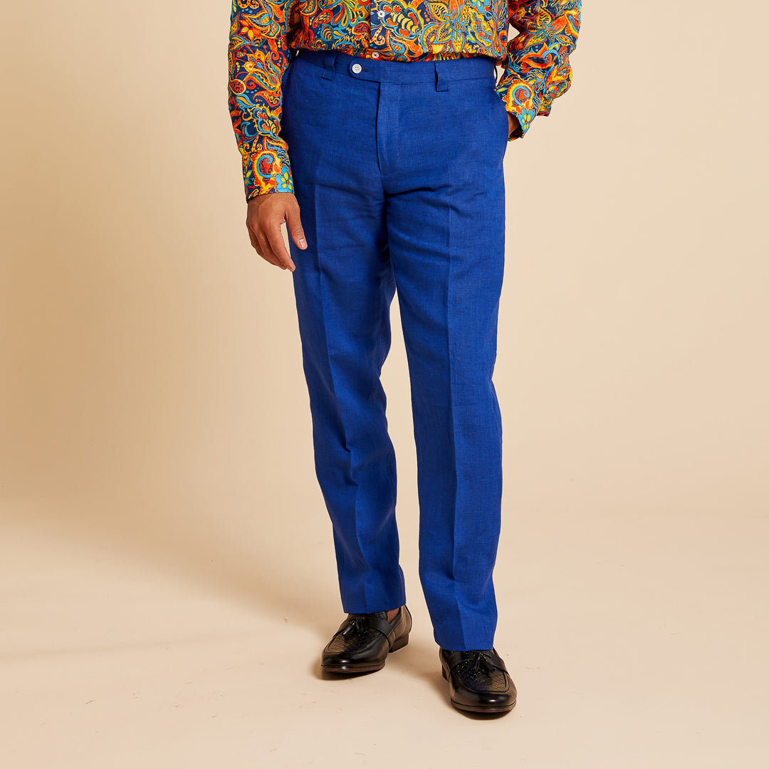 Sporting Inserch Slim Linen Pants P880-00190 in vibrant Estate Blue, paired with a colorful patterned shirt and black lace-up shoes, the individual stands against a plain beige background.