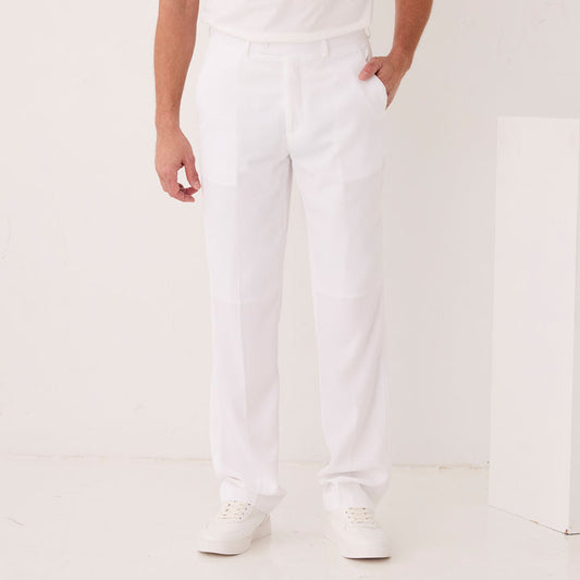 Someone wears Inserch Crepe Flat Front Pants P9356-00002 White by Inserch, paired with a white belt, white sneakers, and a white shirt, standing against a plain white background with one hand in their pocket.