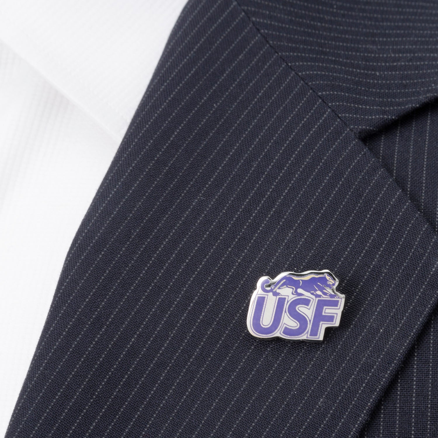 The NCAA University of Sioux Falls Lapel Pin by Cufflinks.com features silver-toned "USF" letters in purple, accented by a leaping panther to represent the University of Sioux Falls Cougars.