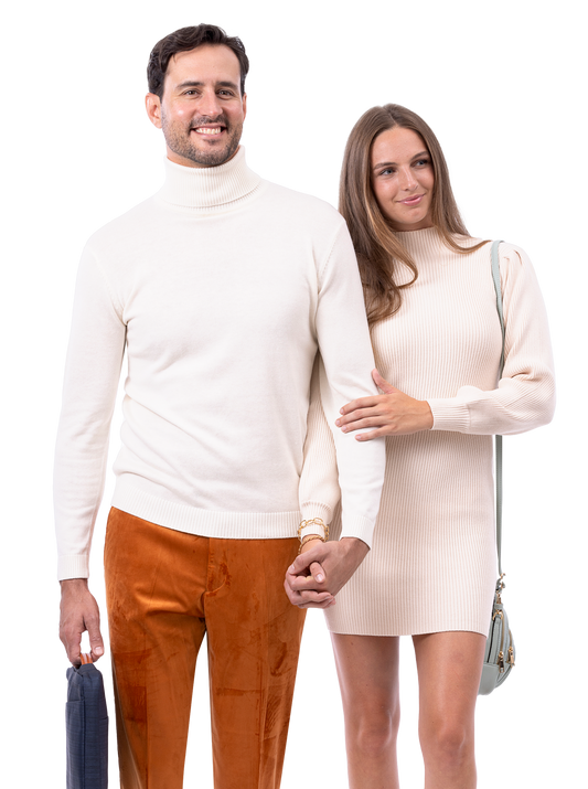 A man and woman stand together, both wearing light-colored sweaters. The man holds an EJ Samuel Rust Pants PV01 bag as they hold hands. The woman smiles.