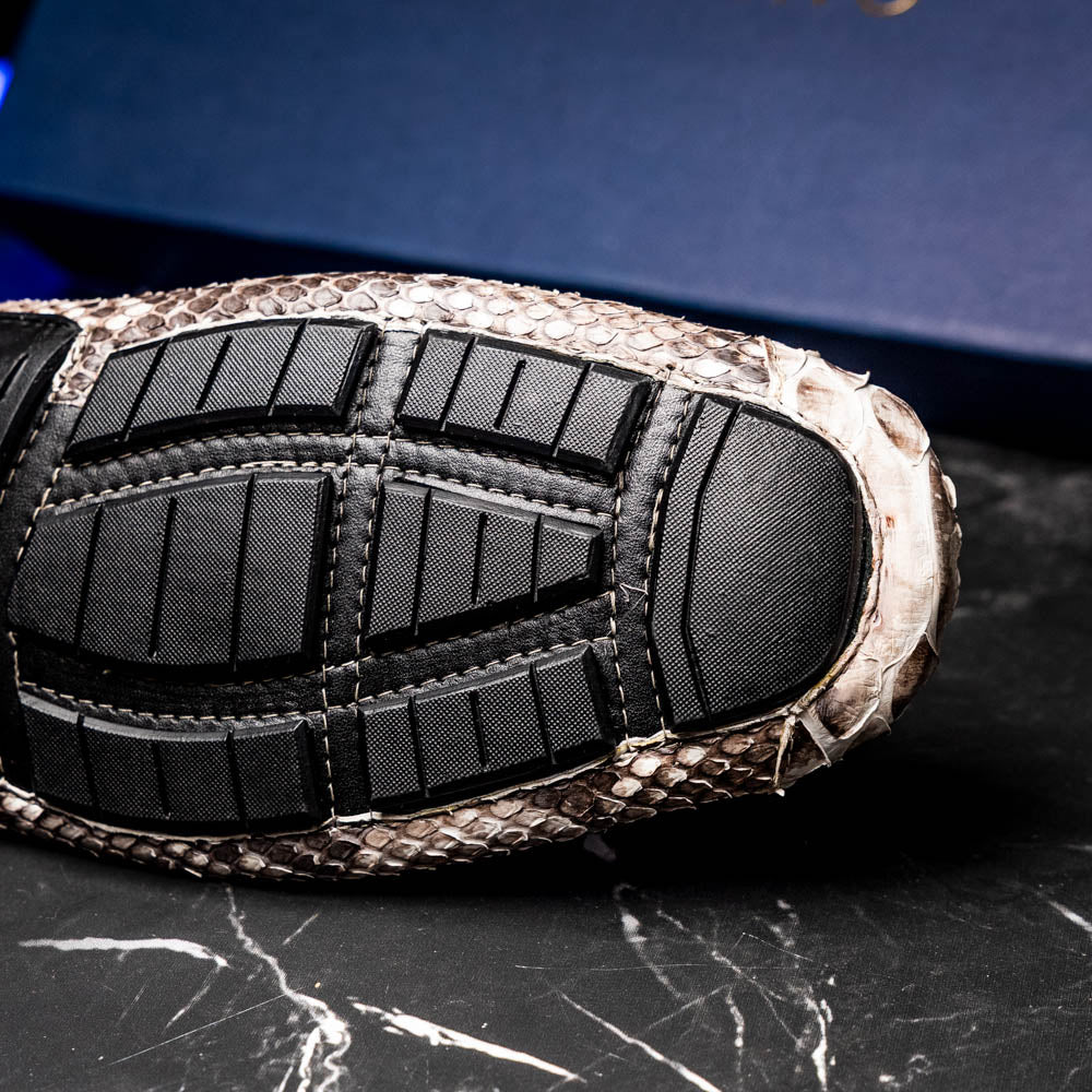 Pair of Marco Di Milano’s Pia Natural men’s loafers, crafted from exotic python skin leather and featuring a sleek metal buckle detail, displayed against a white background. One luxury loafer stands upright while the other is tilted to reveal the sole, showcasing the refined craftsmanship of these signature driver shoes.