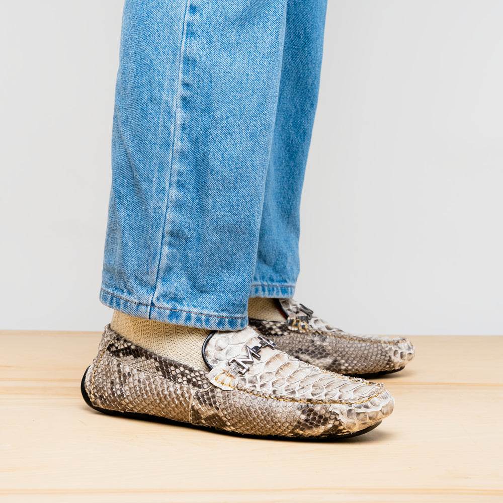 Pair of Marco Di Milano’s Pia Natural men’s loafers, crafted from exotic python skin leather and featuring a sleek metal buckle detail, displayed against a white background. One luxury loafer stands upright while the other is tilted to reveal the sole, showcasing the refined craftsmanship of these signature driver shoes.