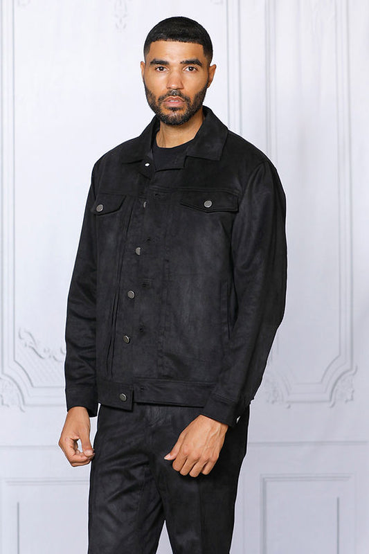A man with short hair and a beard stands facing forward, wearing the Insomnia INSOMNIA ROMEO 2PC Black Vegan Suede Leisure Suit, set against a light-colored ornate wall.