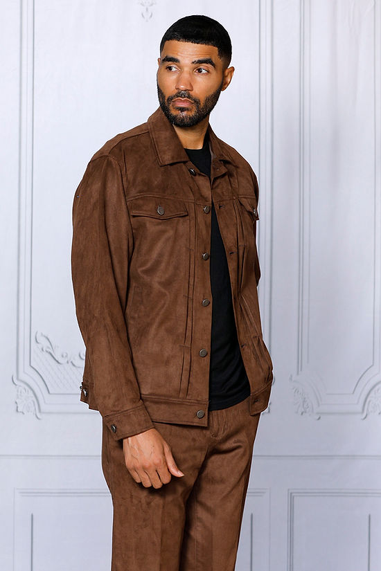 A man wearing the INSOMNIA ROMEO 2PC Brown Vegan Suede Leisure Suit by Insomnia stands against a white wall with decorative molding, looking to the side.