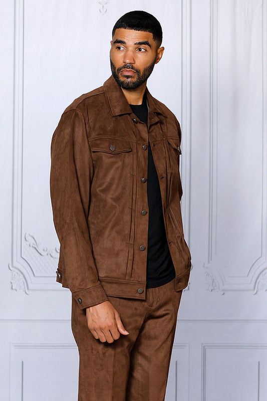 A man wearing the INSOMNIA ROMEO 2PC Brown Vegan Suede Leisure Suit by Insomnia stands against a white wall with decorative molding, looking to the side.