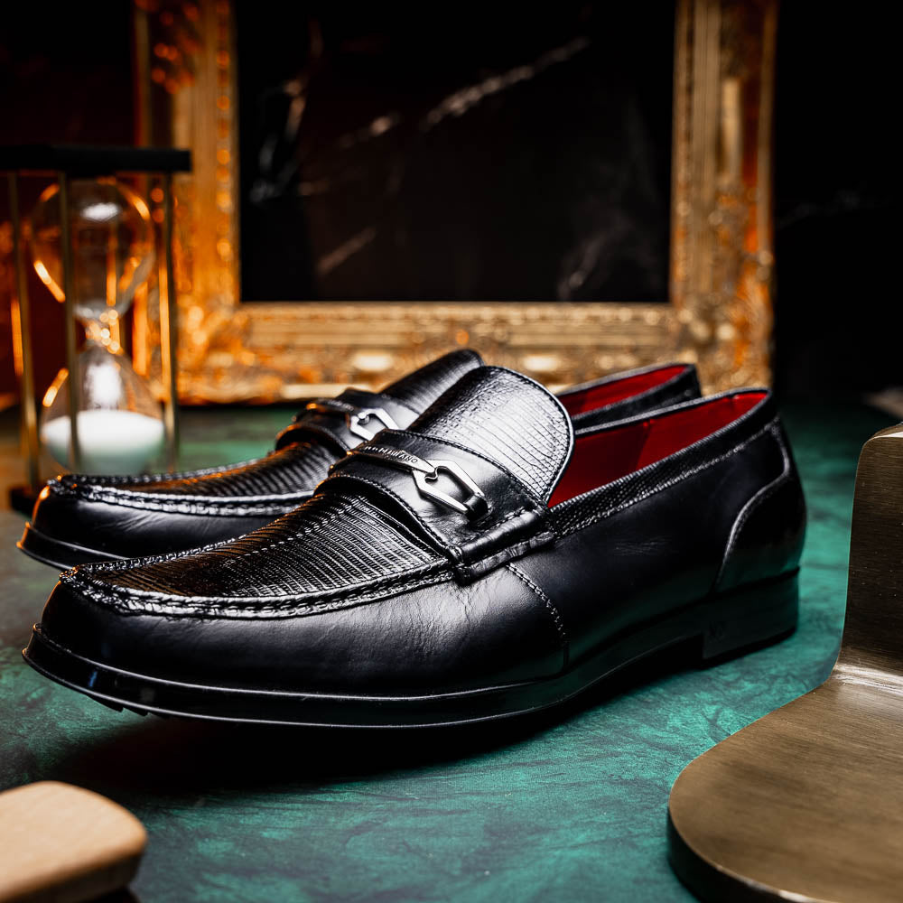 The Ravello Black by Marco Di Milano is a pair of black leather loafers with metal accents, textured uppers, a red interior lining, and ribbed rubber soles—making an exquisite statement in luxury footwear.