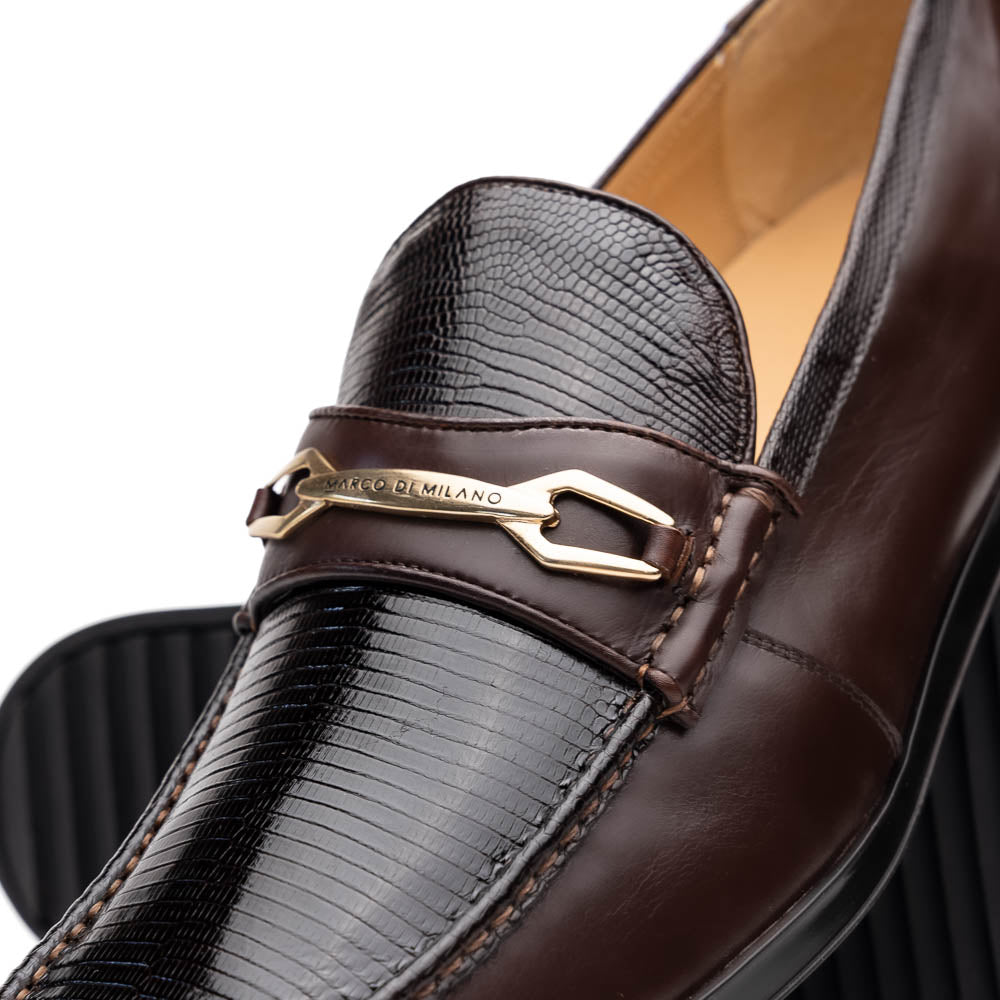 The Marco Di Milano Ravello Brown loafers, crafted from genuine lizard with a metal buckle, are showcased with one shoe upright and the other on its side to highlight the elegant hand-painted finish.