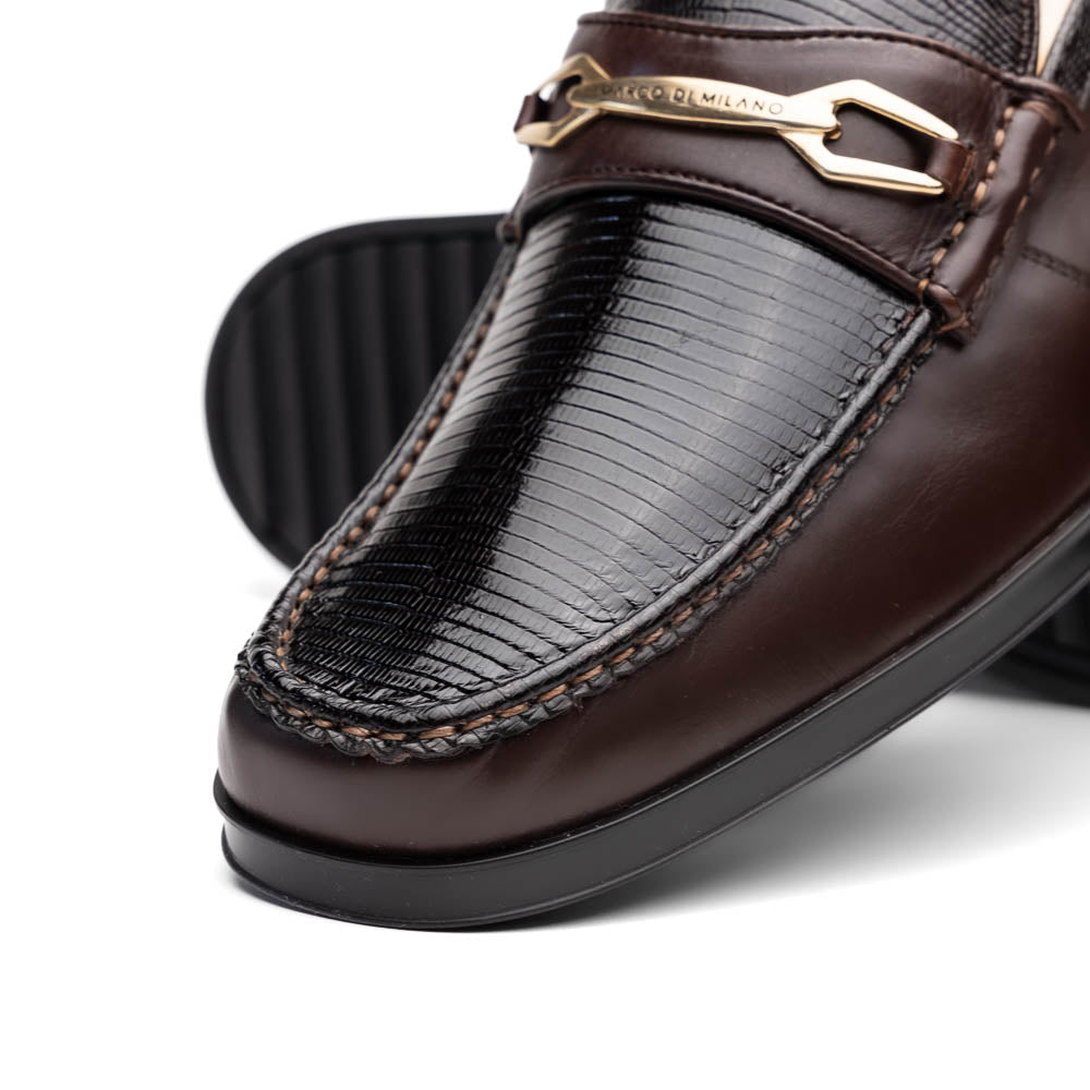 The Marco Di Milano Ravello Brown loafers, crafted from genuine lizard with a metal buckle, are showcased with one shoe upright and the other on its side to highlight the elegant hand-painted finish.