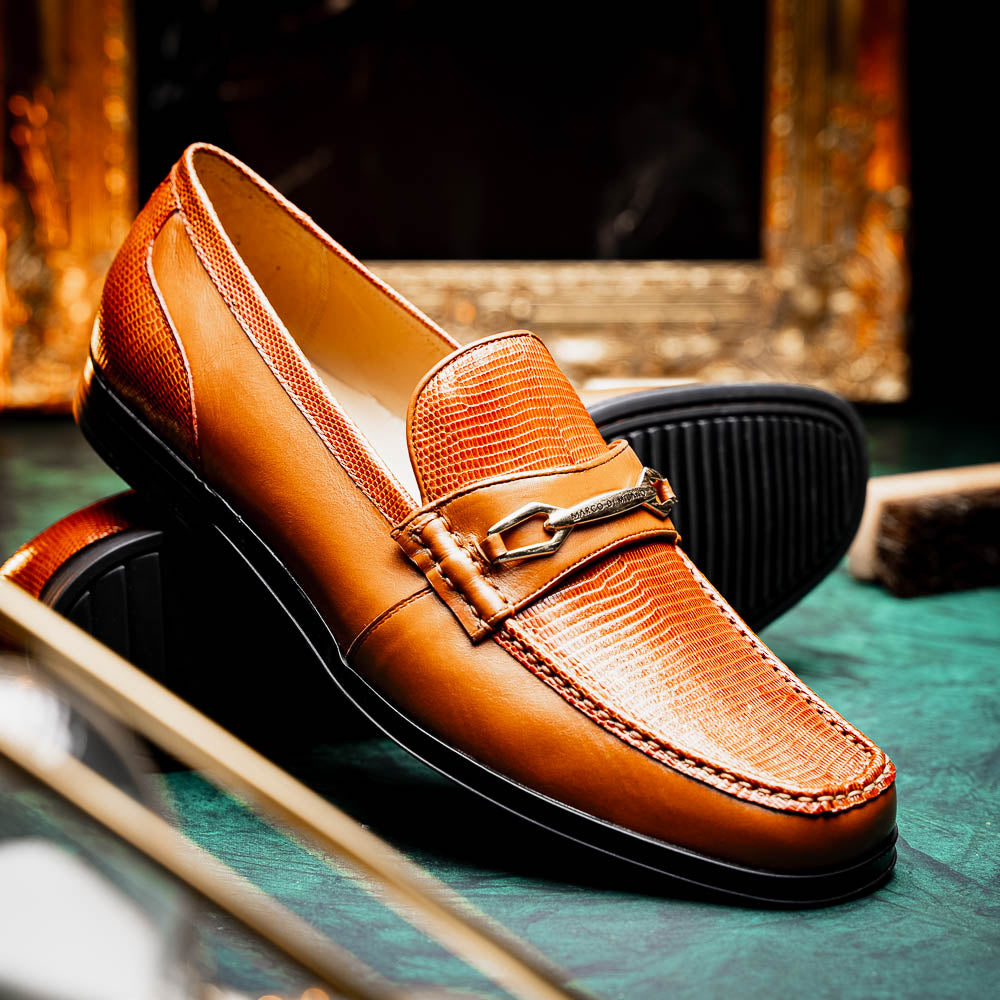 The Marco Di Milano Ravello Honey is a brown leather loafer with a textured finish and metal detail, displayed upright and on its side to show the rubber sole—ideal for those seeking luxury footwear.