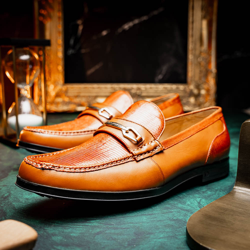 The Marco Di Milano Ravello Honey is a brown leather loafer with a textured finish and metal detail, displayed upright and on its side to show the rubber sole—ideal for those seeking luxury footwear.